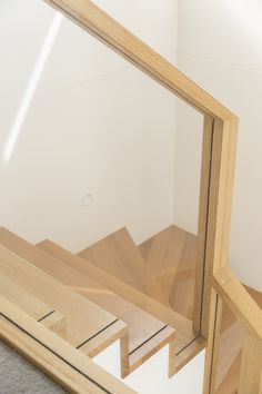 a mirror sitting on top of a wooden floor next to a white wall in a room