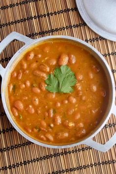 a pot filled with beans and cilantro on top of a table