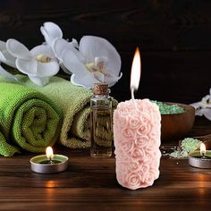 candles and towels on a table with flowers