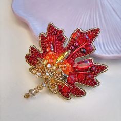 a red brooch sitting on top of a white table