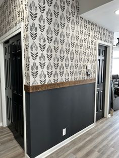 an empty room with black and white wallpaper on the walls next to a door