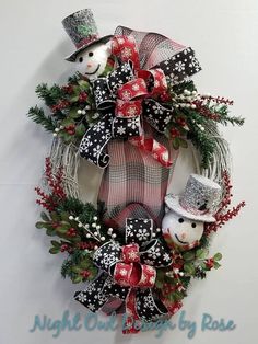 a christmas wreath with two snowmen on it