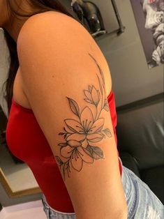 a woman's arm with a flower tattoo on the left side of her arm