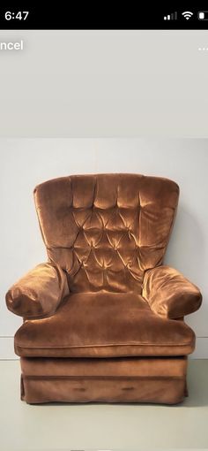 a brown chair sitting on top of a white floor next to a wall and a phone