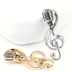 two microphones are next to each other on a white plate with a gold and silver keychain