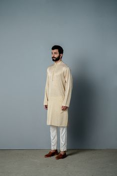 CUSTOM PRINT KURTA IN SOFT COTTON SILK WITH POTLI BUTTON DETAIL ON PLACKET. This is paired with a pair of payjamas Fabric : cotton satin KURTA ALIGHARI PAYJAMA IVORY AND GOLD Color 20 DAYS Delivery DRYCLEN ONLY STORE IN PLASTIC GARMENT BAGS FOR THE PRINT TO RETAIN SHINE Cream Cotton Silk Long Sleeve Sets, Cream Long Sleeve Cotton Silk Sets, Traditional Eid Kurta For Loungewear, Traditional Long Sleeve Kurta For Loungewear, Beige Cotton Sets With Dabka Detailing, Cream Cotton Traditional Wear With Long Sleeves, Traditional Festive Loungewear Sets, Festive Traditional Loungewear Set, Cream Long Sleeve Cotton Traditional Wear