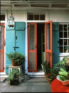 an orange and blue house with potted plants