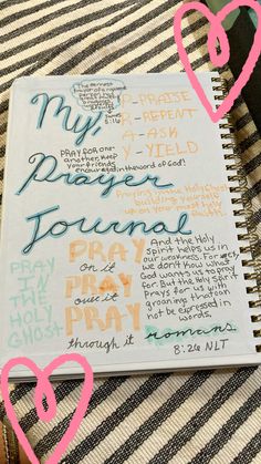 an open notebook with writing on it and two pink hearts in the middle that read, my prayer journal