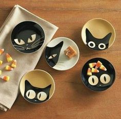 black cat plates and bowls with candy on them