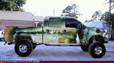 the truck is painted with fish on it's body and has four wheels, two tires