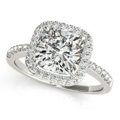 a cushion cut diamond ring with pave diamonds around it