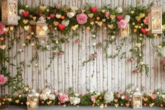 an arrangement of flowers and lanterns on a wall