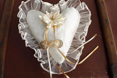 a white heart shaped pillow sitting on top of a wooden table