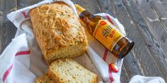 a loaf of beer bread and two slices on a towel with a bottle of beer