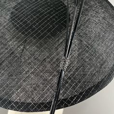 A seductive Dior style saucer in black sinamay strawcloth, with silver lurex thread. Simply and strikingly trimmed with two arrow feathers and one ostrich quill in black. Elastic and comb attachment for easy, comfortable wear. Lifted Millinery headwear is constructed with time honored techniques and fine craftsmanship. All hats are meticulously blocked and sewn by hand without the use of adhesives to attach trims. This ensures a long lasting hat with the ability to be retrimmed throughout the ye Elegant Black Fascinator For Evening, Evening Fascinator With Feather Trim, Classic Adjustable Fascinator For Evening, Classic Evening Fascinator With Adjustable Fit, Black Sinamay Fascinator For Kentucky Derby, Elegant Black Fascinator With Feather Trim, Elegant Black Sinamay Hat, Elegant Black Feathered Fascinator, Elegant Black Fascinator With Feathers