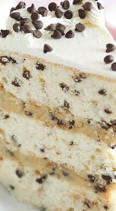 a slice of cake with white frosting and chocolate chips