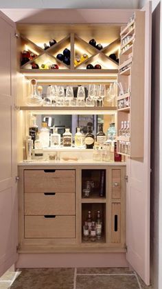 an open cabinet with liquor bottles on the shelves