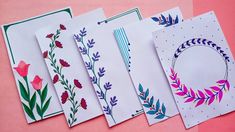 four cards with different designs on them sitting next to each other in front of a pink background