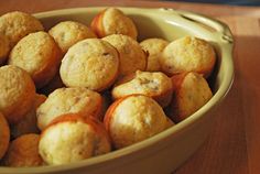 a bowl filled with muffins sitting on top of a wooden table