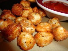 some fried food is next to a bowl of tomato soup