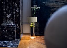 a vase with some flowers in it sitting on the floor