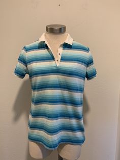 This is a nice vintage polo shirt. There are no tags or label. It measures like a small men's or a women's medium. Turquoise and white stripes with a white collar. There are two Metal Snaps for closure. It has a very small mark as shown in last photo, otherwise in great condition. I will be mailing this Priority Mail and First Class International. Measurements Bust or Chest ~ 36 Inch Waist ~ 34 Inch Shoulder to Shoulder ~ 15 Inch Length ~ 24 Inch Vintage Blue Collared T-shirt, Light Blue Polo Shirt For Spring, Retro Blue Polo Collar T-shirt, Vintage Blue Short Sleeve Polo Shirt, Blue Vintage Short Sleeve Polo Shirt, Vintage Blue Polo Shirt, Retro Blue Short Sleeve Polo Shirt, Blue Retro Short Sleeve Polo Shirt, Vintage Polo Shirt