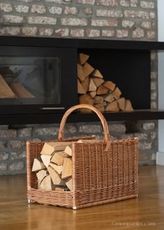 a wicker basket sitting on top of a wooden floor next to a fire place