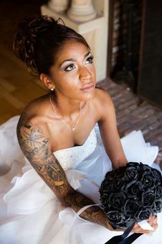 a woman in a wedding dress holding a bridal bouquet and looking at the camera