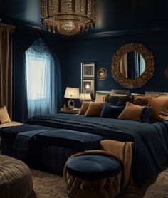 a bedroom decorated in blue and gold with a large bed, ottomans, lamps, and chandelier