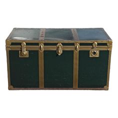 an antique trunk with brass trimmings and leather straps on the sides, sitting against a white background