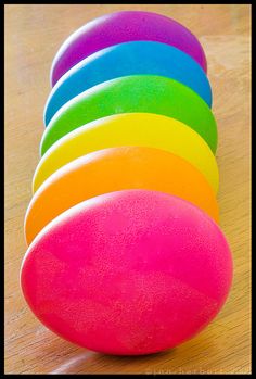 a row of colored balls sitting on top of a wooden table