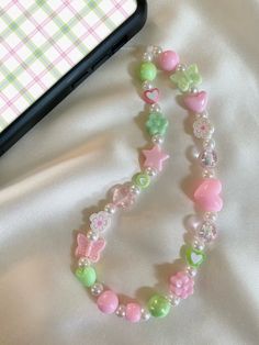 ♡ Pastel Pink and Green Phone Charm/Strap ♡ Approximately 7 inches in length from top of cord to bottom of beads ♡Made with: * white waxed cord * beige acrylic pearls * plastic and clay beads ♡ Beads and bead colors may vary but will look very similar to the phone charm pictured ♡ Please contact me if you have any questions or any bead color preferences Phone Charms Pastel, Pink And Green Phone Case, Pink And Green Accessories, Phone Beads Strap Aesthetic, Pastel Phone Charm, Pink Phone Charm Aesthetic, Kandi Phone Charm, Cute White Pearl Beaded Necklaces, Cute Spring Adjustable Beaded Necklaces