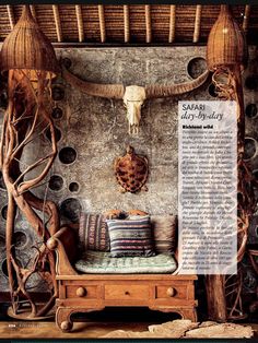 an old wooden bench sitting in front of a wall with antlers on it's head