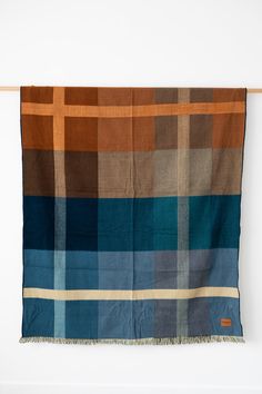 a blue and brown plaid blanket hanging on a wall