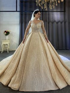 a woman in a wedding dress standing next to a chandelier