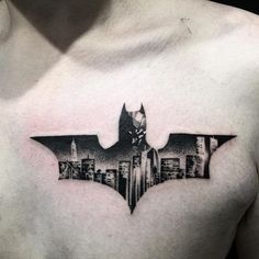 a batman tattoo on the chest is shown in black and grey colors, with cityscape behind it