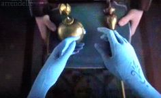 two hands in blue gloves holding brass objects