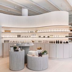 the inside of a store with white walls and shelves filled with different types of bottles