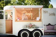 a dog is sitting in the window of a food truck that sells donuts and other treats