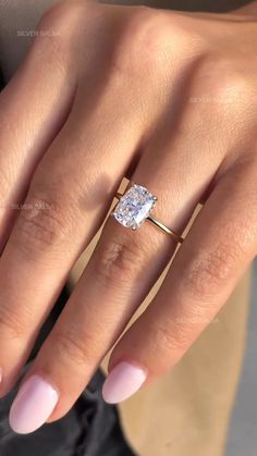 a woman's hand with a ring on it and a diamond in the middle