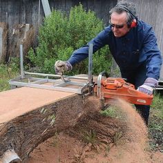 a man using a chainsaw to cut down a tree