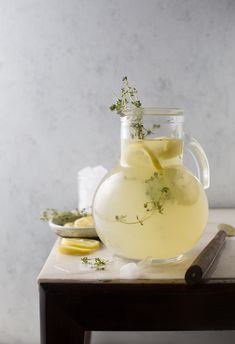 a pitcher filled with lemonade sitting on top of a table