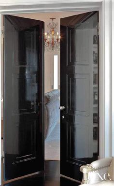 an open door leading to a bedroom with a chandelier hanging from the ceiling