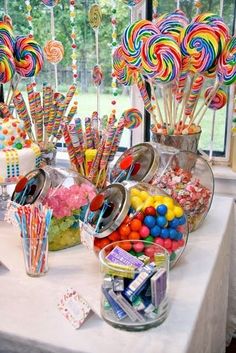 a table topped with lots of candy and lollipops on top of it