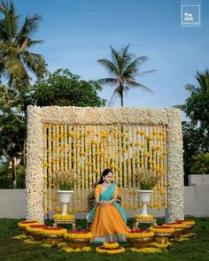 a woman sitting in front of a flower display