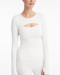 DETAILS: Color: Cream Ribbed knit long sleeve top with front cut out detail 93% Polyester, 7% Spandex Machine wash SIZE & FIT: Fits true to size Length: 23" Bust: 12 3/8" Bottom: 13 1/8" Model is 175cm/ 5'9" and is wearing a size Small Long Sleeve Tops With Thumbholes, Long Sleeve Tops With Thumbholes And Minimal Stretch, Long Sleeve Top With Thumbholes And Minimal Stretch, Chic Tops With Thumbholes And Minimal Stretch, Chic Cutout Tops In Elastane, Long Sleeve Top With Thumbholes For Layering, Elastane Long Sleeve Top With Thumbholes For Layering, Chic Fitted Long Sleeve Top With Thumbholes, Fitted White Cutout Tops