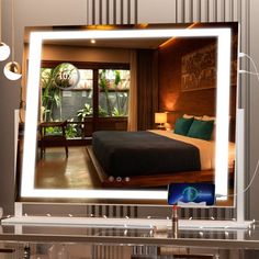 an image of a bedroom with a large mirror on the wall and lights in front of it