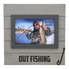 an image of a man holding a fish in front of the words out fishing on it