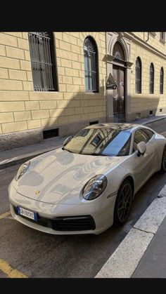 a silver sports car parked on the side of a street