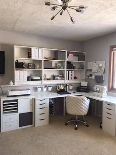 a home office with white cabinets and drawers